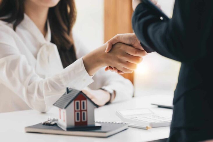 gente imobiliário a apertar a mão de cliente