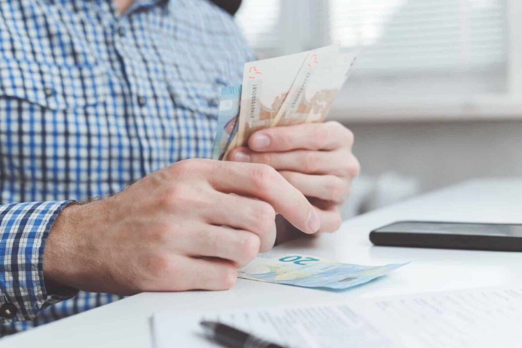 Recebeu uma proposta de emprego? Entenda o que lhe estão a oferecer homem a contar dinheiro. Ilustração de artigo sobre subsídios em duodécimos