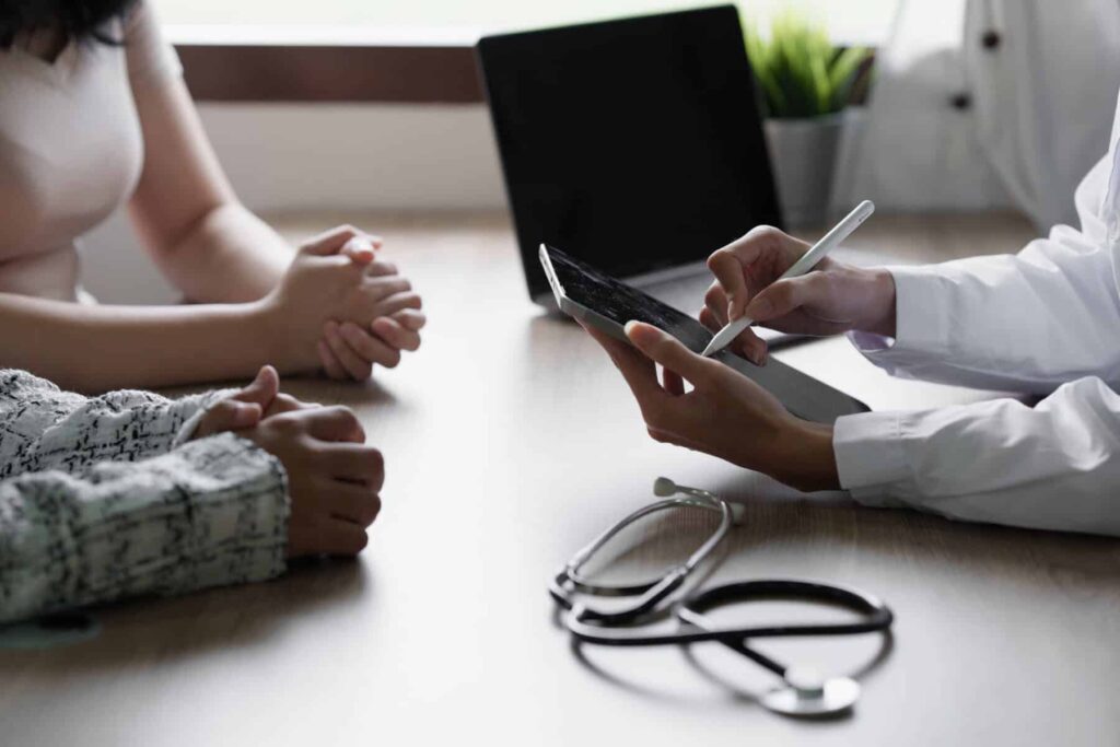 Consulta médica, em que um médico apresenta o resultado de exames aos pacientes.