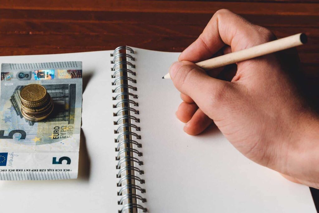 pessoa com caderno aberto a apontar as mudanças de preços em 2025