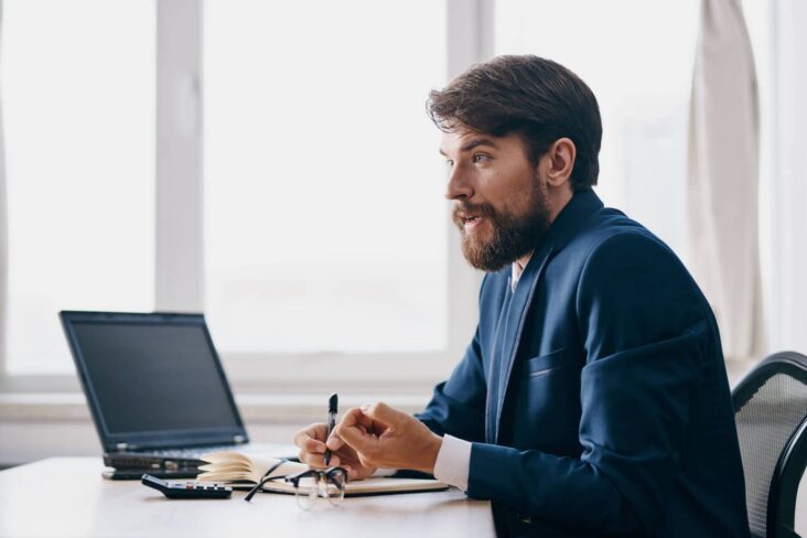 homem sentada à secretária em frente ao portátil a verificar se tem incidentes no Banco de Portugal
