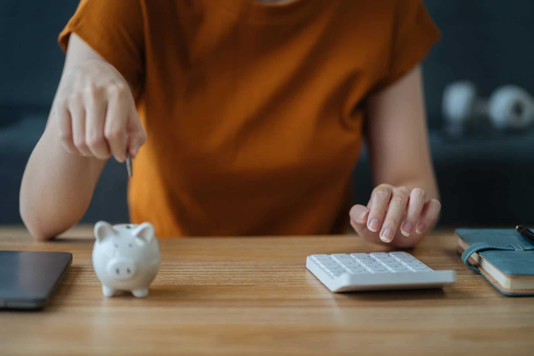 jovem mulher a fazer contas para perceber se no IRS Jovem compensa mais o desconto mensal ou após entregar a declaração de IRS.