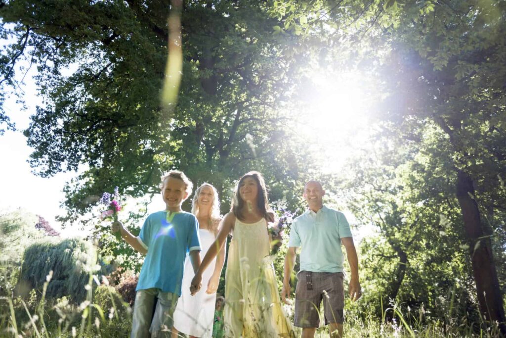 Retenção na fonte: Com ou sem dependentes? O que as famílias devem saber Família composta por um casal de pais e um casal de filhos, passeia na floresta