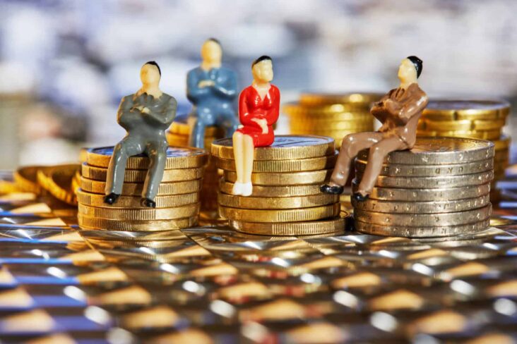 Figuras, representativas de pessoas, sentadas em cima de pequenos montes de moedas.