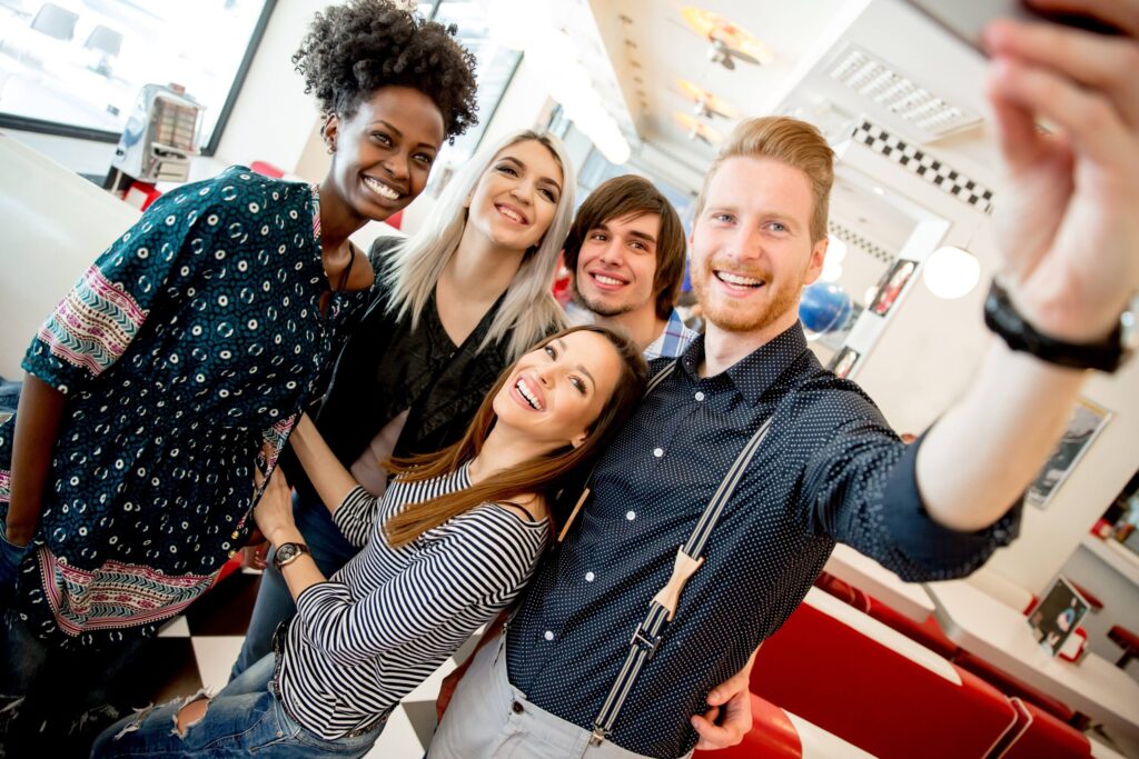 Grupo de jovens, na casa dos 20 anos, pousam para fotografia.