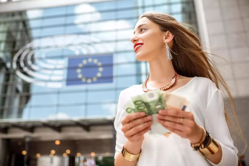 Mulher com notas de euro junto ao parlamento europeu