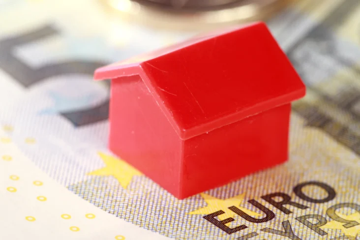 Modelo miniatura de uma habitação em cima de uma nota de cinco euros