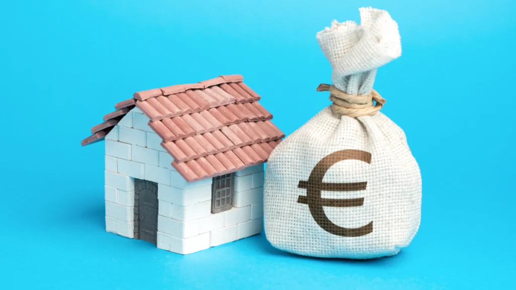 Casa de brincar com saco de dinheiro num fundo azul