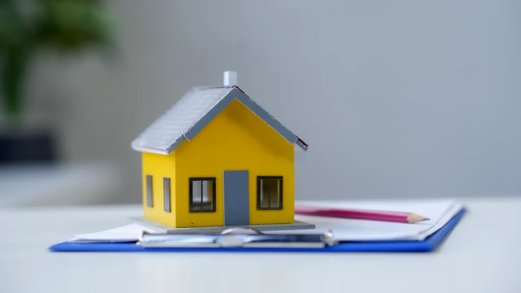 Pequena casa de madeira sobre papéis