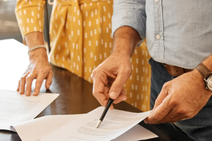 Casal idoso assina papéis
