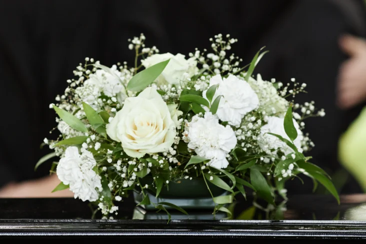 Flores brancas sobre um caixão fechado, funeral