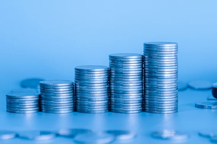 Moedas em escada num fundo azul