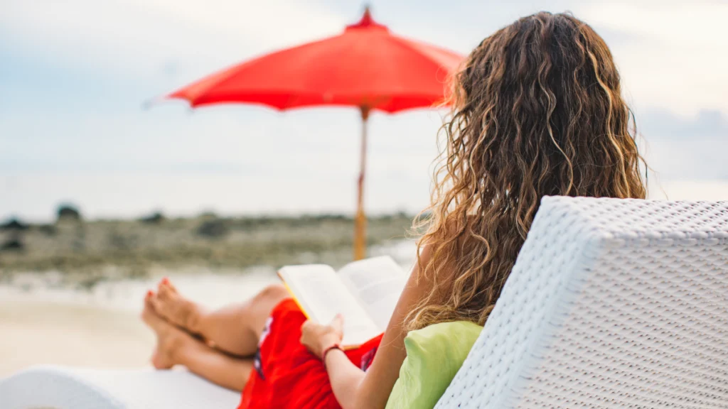 Quer a reforma antecipada sem penalização? Saiba como Mulher relaxa a ler um livro na praia