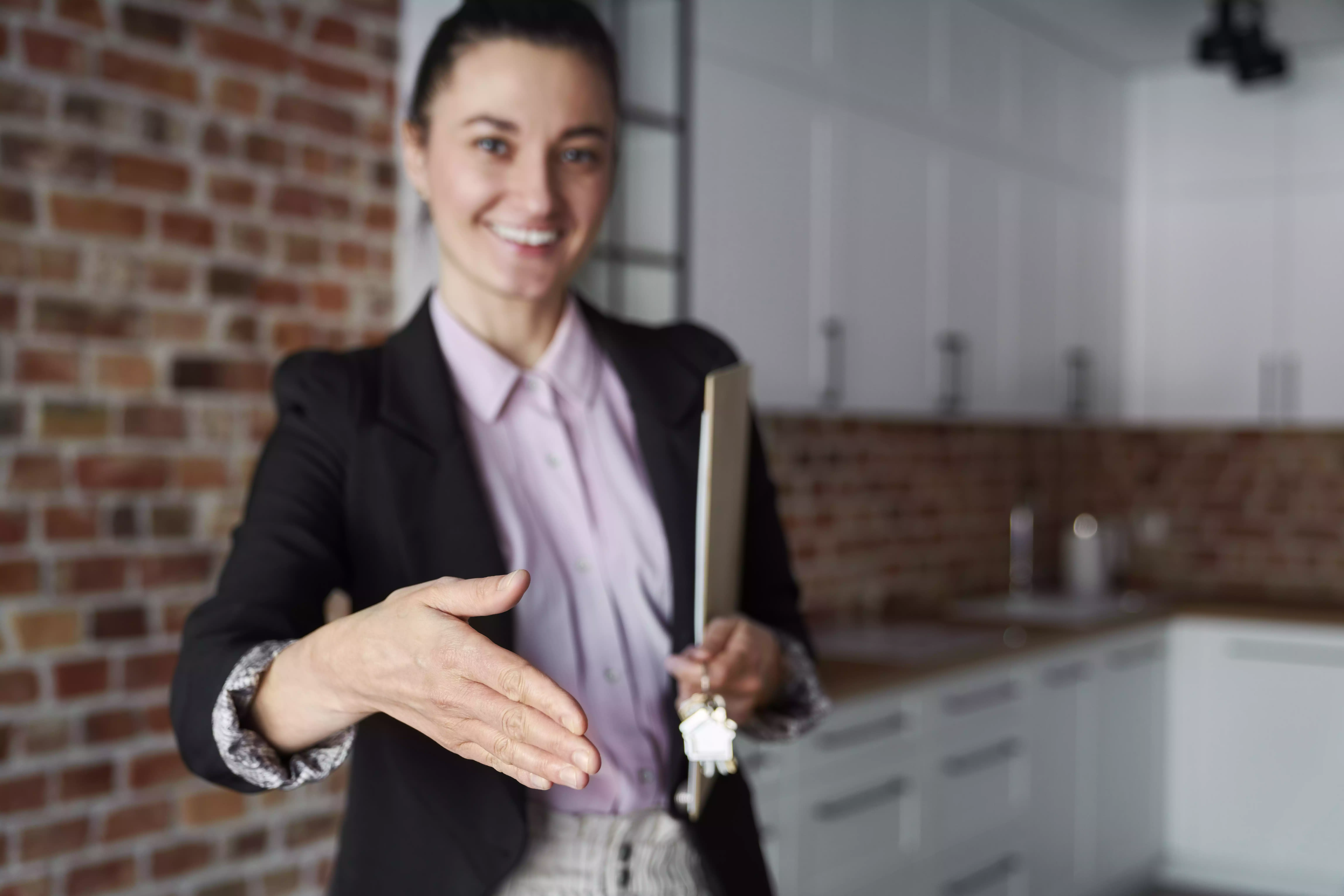 agente imobiliária a estender a mão