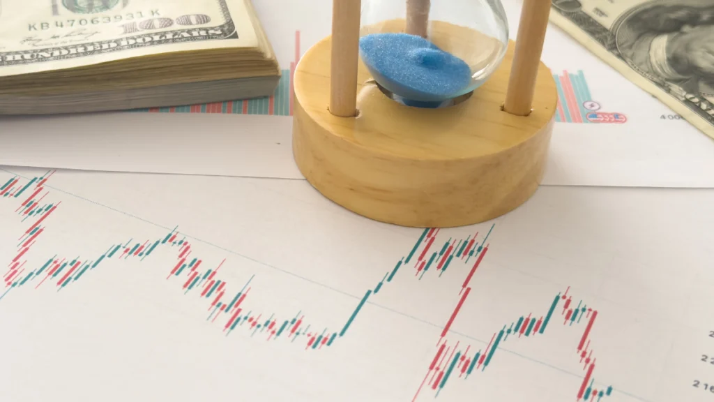 Gráfico de investimentos com uma ampulheta e notas de dólar