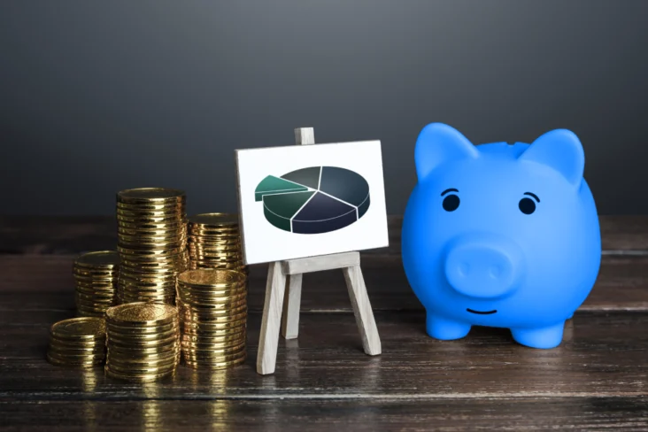 Porco mealheiro azul com moedas e um gráfico